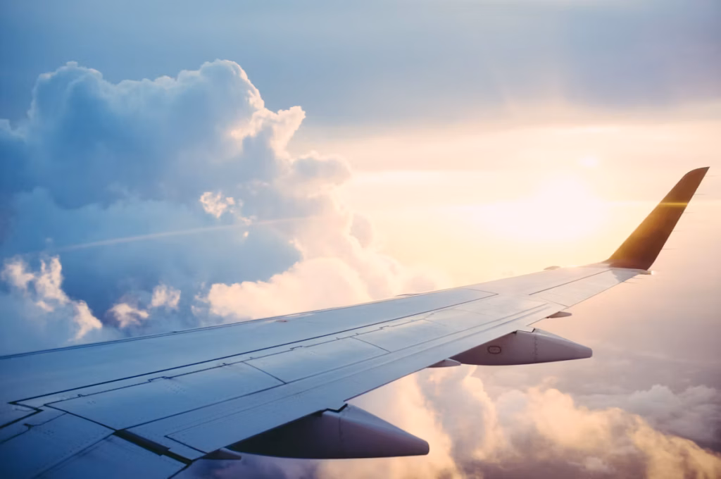 Airplane flying over clouds representing travel insurance coverage for international trips
