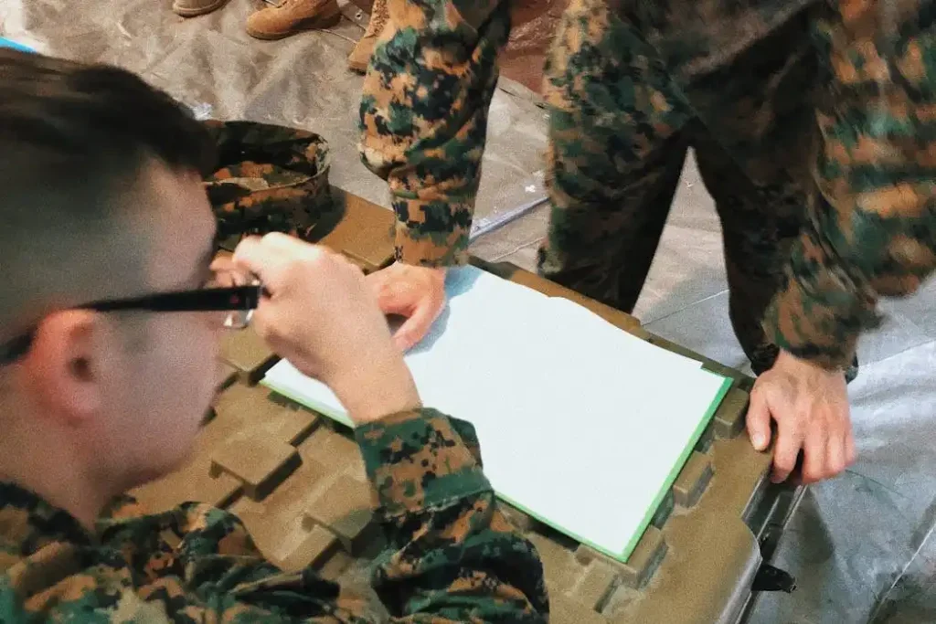 Military personnel reviewing paperwork for Camp Lejeune lawsuit settlements and claims.