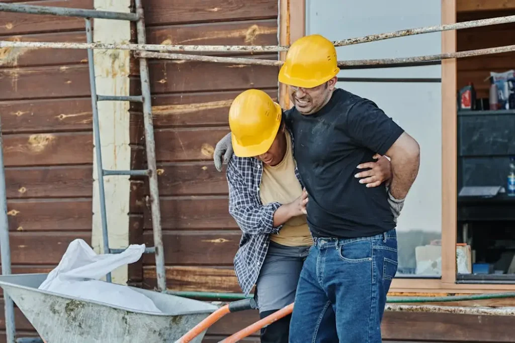 Injured worker being supported on site, illustrating cases a construction accident lawyer handles.
