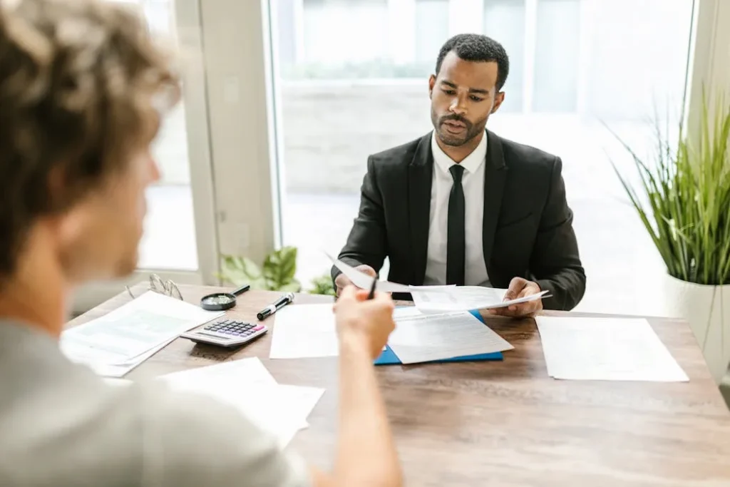 Financial professional discussing documents with a client, illustrating the advisor vs broker dynamic.