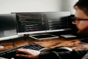 A professional reviewing code on a computer monitor while planning an ERP selection strategy
