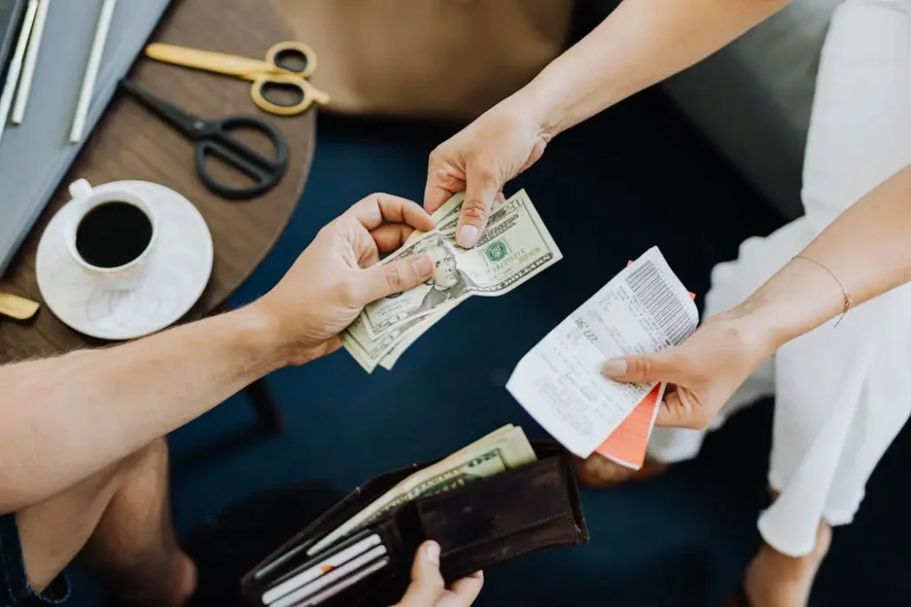 Hands exchanging cash for documents, illustrating how life settlement companies buy unwanted policies for an immediate cash payout.