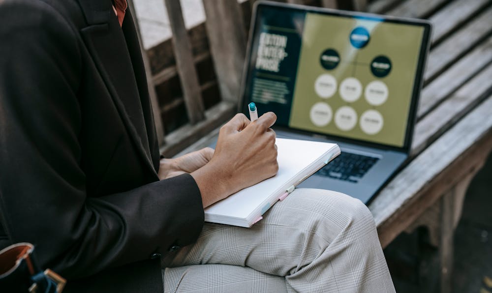 Professional studying outdoors with a laptop, representing the flexibility of the best online MBA programs.