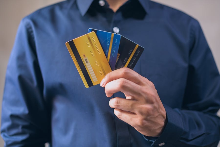 Person holding various credit cards, illustrating how to build your credit score for premium cards.
