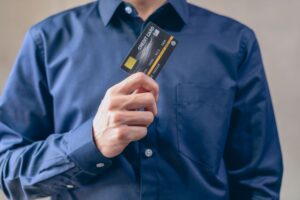 A person holding a new black credit card, representing the goal of getting approved for the best credit cards for no credit history.