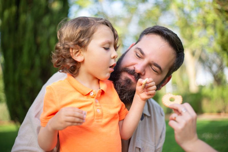 A father smiling while spending quality time outdoors with his young son, highlighting family eligibility for the updated tax credit. (Child Tax Credit 2026 How Much & Who Qualifies.jpg)