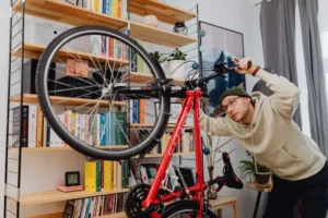 Man keeping his red bike safe indoors—a smart move protected by renters insurance. (Does Renters Insurance Cover Bike Theft.webp)