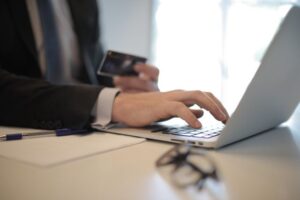 "A businessman entering credit card details on a laptop for an online transaction."