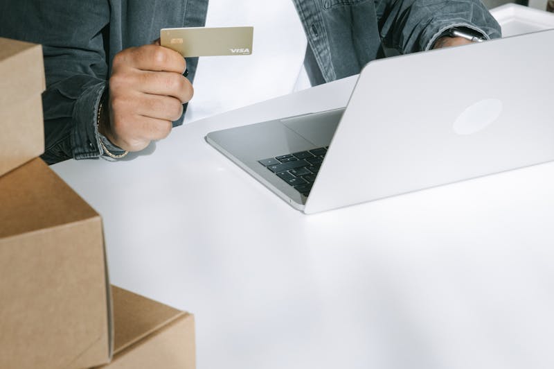 Person using a Visa card at a laptop to build credit online. (How to Build US Credit as a New Immigrant.