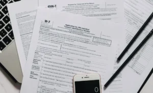 Official IRS tax forms and financial documents on a desk, representing the paperwork needed to apply for the IRS Hardship Program and CNC status.