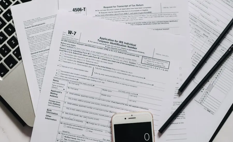 Official IRS tax forms and financial documents on a desk, representing the paperwork needed to apply for the IRS Hardship Program and CNC status.