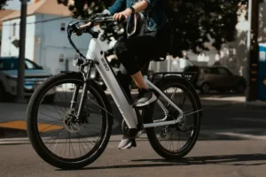 A commuter riding a high-value white electric bike on a city street, illustrating the need for proper renters insurance e-bike coverage against theft.
