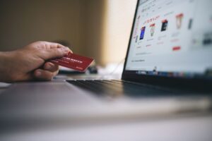 A person holding a credit card while shopping online on a laptop computer