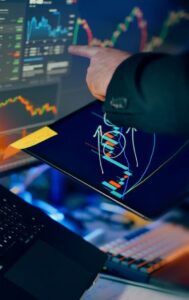 An investor pointing at candlestick charts on a tablet and computer screen, analyzing financial market trends and stock data.